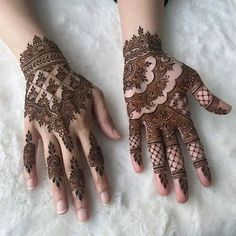 two hands with henna tattoos on them