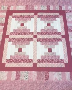 a pink and white quilt with squares on it