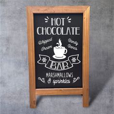 a chalkboard sign advertising hot chocolate and marshmallows on a gray wall