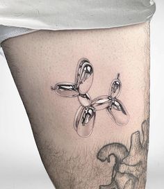 a man's thigh with an artistic tattoo design on it