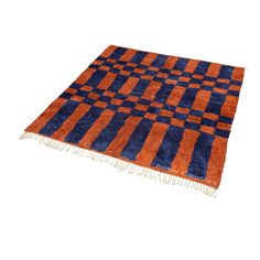 an orange and blue rug with fringes on it's edges is shown in front of a white background