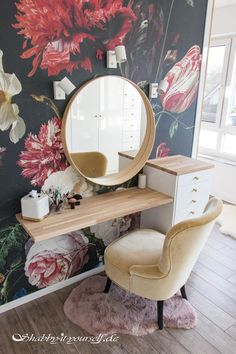 a desk with a mirror, chair and flower wallpaper