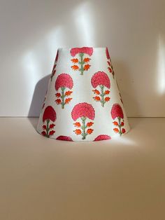 a white lamp shade with red flowers on it