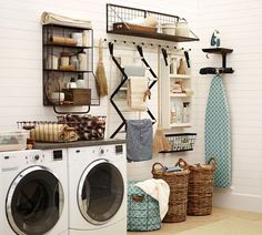 an image of a laundry room with clothes hanging on the wall and other items in baskets