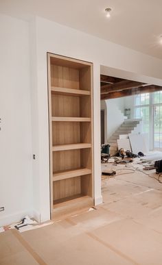 an unfinished room with open shelves and tools on the floor