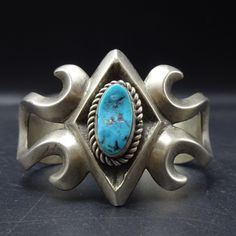 CLASSIC VINTAGE SAND CAST STERLING SILVER and TURQUOISE BRACELET DESCRIPTION:  With a gorgeous specimen of natural blue Kingman turquoise, this classic bracelet will be a cherished addition to your collection of fine vintage Southwestern and Native American jewelry. MEASUREMENTS: Interior of the cuff measures 5 1/4" with an additional 7/8" slightly adjustable gap. Total circumference:  6 1/8" Measures 2 1/8" straight across the widest part  (from wrist bone to wrist bone) Bracelet face measures Blue Collectible Cuff Bracelet Bangle, Southwestern Blue Cuff Bracelet With Patina, Southwestern Blue Patina Cuff Bracelet, Blue Patina Bracelet Jewelry, Vintage Blue Cuff Jewelry, Blue Patina Bracelet, Handmade Blue Cuff Bracelet For Formal Occasions, Unique Blue Cuff Bracelet For Formal Occasions, Blue Unique Cuff Bracelet For Formal Occasion