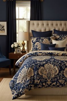 a bed with blue and white comforters in a bedroom next to a window,