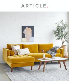 a yellow couch sitting on top of a white rug