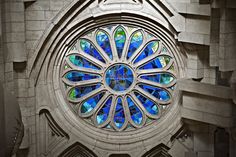 a large stained glass window on the side of a church building with arches and columns