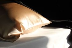 a close up of a pillow on top of a bed with black sheets and pillows