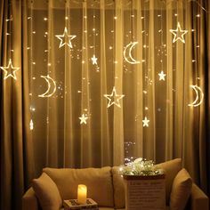 a living room filled with furniture and stars hanging from the ceiling above it's windows