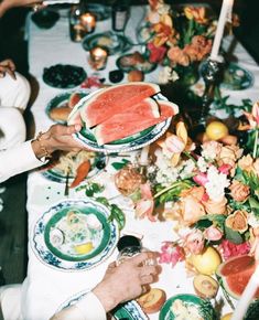 a table is set with watermelon slices and flowers