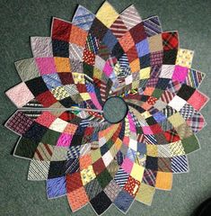 a multicolored patchwork quilt is arranged in the shape of a circular flower