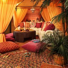 a living room with orange drapes and pillows