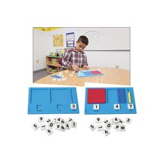 a young boy is sitting at a table playing with numbers and magnets in front of him