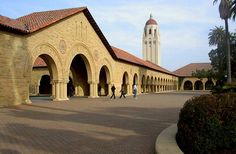 people are walking around in front of an old building with arches and arched doorways