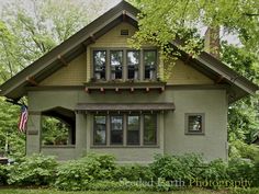 a green house in the woods with lots of trees