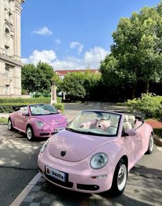 two pink cars parked in front of a building