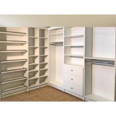 an empty closet with white shelves and drawers