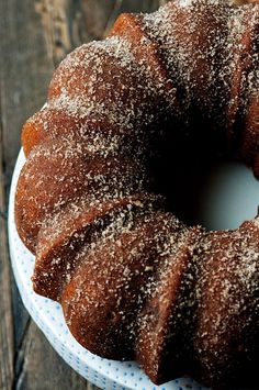 a bundt cake with powdered sugar on top sitting on a white platter