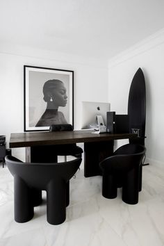 a black and white photo sitting on top of a wooden table next to two chairs