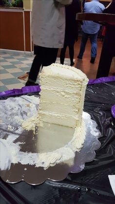 a piece of white cake sitting on top of a table next to a purple plate