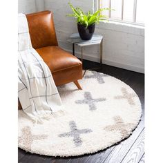 a living room area with a chair, rug and potted plant on the floor