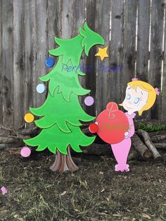 a wooden christmas tree next to a fence