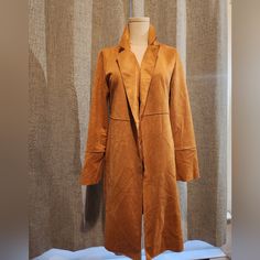 Material Is Soft, Faux Suede. Caramel Color Size S/P. Falls Right Below The Knees. Camel Outerwear For Fall Workwear, Camel Outerwear For Work During Fall, Camel Outerwear For Work In Fall, Chic Camel Outerwear With Pockets, Camel Long Coat For Spring, Spring Camel Long Coat, Long Camel Coat For Spring, Chic Camel Outerwear For Work, Spring Camel Outerwear With Pockets