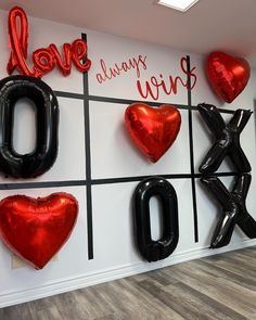 balloons are arranged on the wall to spell love