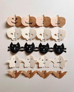 several wooden cut outs with cats and bats attached to each one's head, all in different shapes and sizes