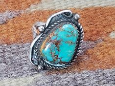 Vintage Silver and Genuine Kingman Turquoise size 6 ring handmade and signed by Navajo artist. This ring  features one large irregular shaped Turquoise stone in a silver sawtooth bezel split shank mounting with bead and rope adornment. Like all of my Native American jewelry, this is real Turquoise. The stone measures 12 mm x 16 mm.  The overall measurement of the top is 17 mm x 25 mm or 1" x 3/4" Weight 5.51 grams Artist mark illegible All of my Native American jewelry is vintage, purchased in t Western Style Untreated Turquoise Ring Gift, Untreated Western Style Turquoise Ring Gift, Untreated Western Turquoise Ring As Gift, Southwestern Turquoise Concho Ring As A Gift, Southwestern Style Turquoise Concho Ring As Gift, Southwestern Stamped Turquoise Ring, Southwestern Style Stamped Turquoise Ring As Gift, Southwestern Stamped Turquoise Ring Gift, Western Style Stamped Turquoise Ring Gift