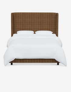 a bed with a brown headboard and white sheets