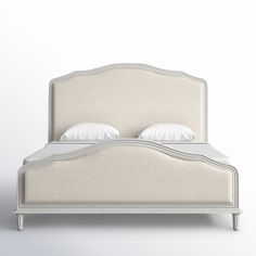 a white bed with two pillows on the headboard and one pillow in the middle