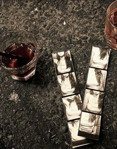 three chocolate squares sitting on top of a table next to a glass filled with liquid