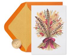 a greeting card with an orange envelope and gold wax stamp