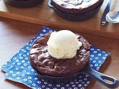 two chocolate desserts with ice cream sitting on top of a blue napkin next to each other