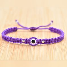 Fashionable And Durable Hand-Made Purple String Bracelet With An Evil Eye Charm For Wrist Sizes From 6 To 9 Inches. With An Easy To Use Zip Like Function To Fit Your Wrist, You'll Have It On As Soon As You Get It. Made From High-Quality Purple String, It Will Be Sure To Last. Wearing An Evil Eye As An Amulet Is Believed To Provide Protection Against Evil Forces. The Evil Eye Meaning Has Symbolism In Almost Every Country In The World And In Every Religion. Each Bracelet Is Carefully Handcrafted A Purple Resizable Bracelets For Friendship, Adjustable Purple Bracelet With Cord, Purple Adjustable Bracelets As Gift, Purple Bracelets With Adjustable Cord, Purple Adjustable Cord Bracelets, Purple Adjustable Bracelet For Gift, Purple Adjustable Length Bracelet As Gift, Adjustable Resizable Purple Bracelets, Adjustable Length Purple Bracelets