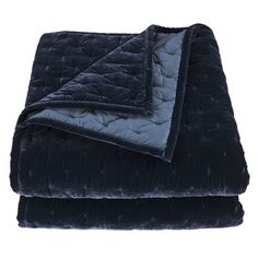 the blue blanket is laying on top of the black bedding set with two pillows