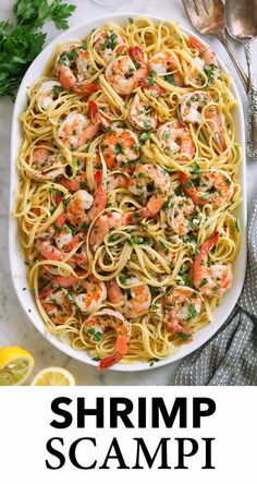 shrimp scampi pasta in a white bowl with lemons and parsley on the side