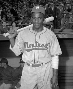 an old photo of a baseball player holding a bat