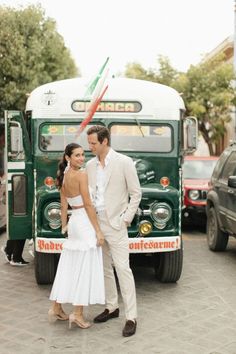 a man and woman standing in front of a bus