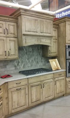 a kitchen with wooden cabinets and granite counter tops in a store or showroom area