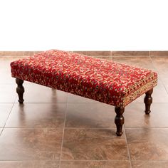 a red bench sitting on top of a tiled floor