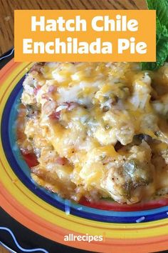 a colorful plate topped with cheese covered enchilada