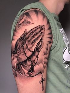 a man wearing a green shirt has a rosary and praying hands tattoo on his arm