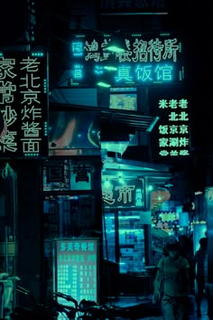 a man walking down a street at night with neon signs on the buildings behind him