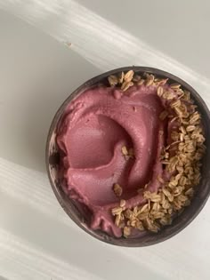 a bowl filled with pink ice cream on top of a white table