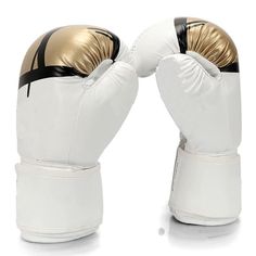 two white and gold boxing gloves sitting on top of each other