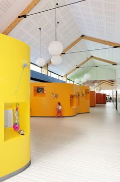 an empty room with yellow walls and white flooring is pictured in this image, there are two people standing on the other side of the wall